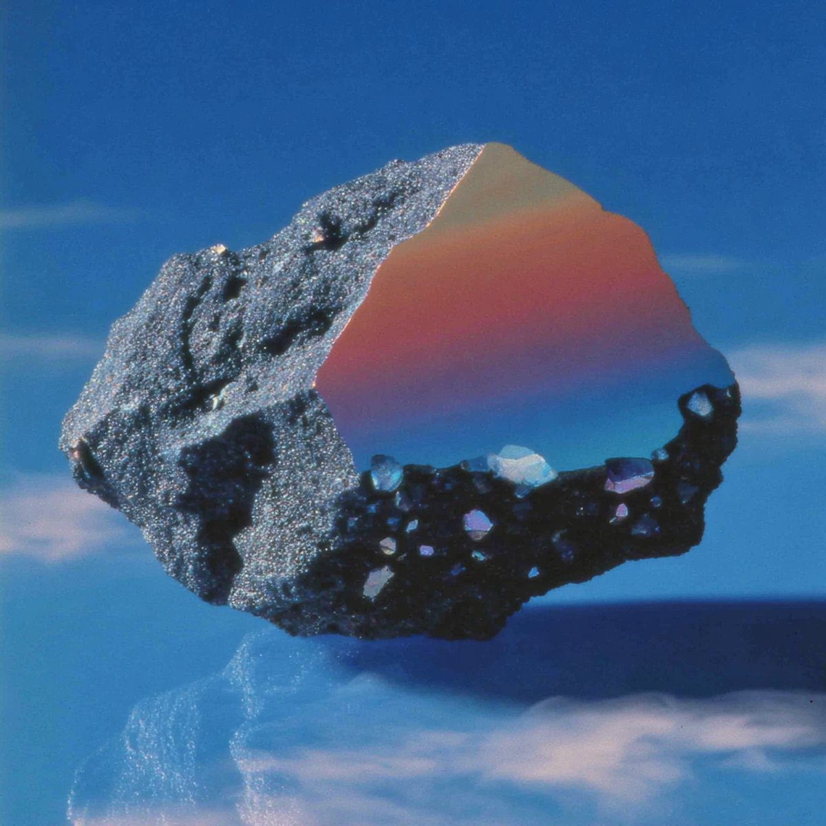 The Object — an iridescent mineral fragment suspended against a cobalt sky